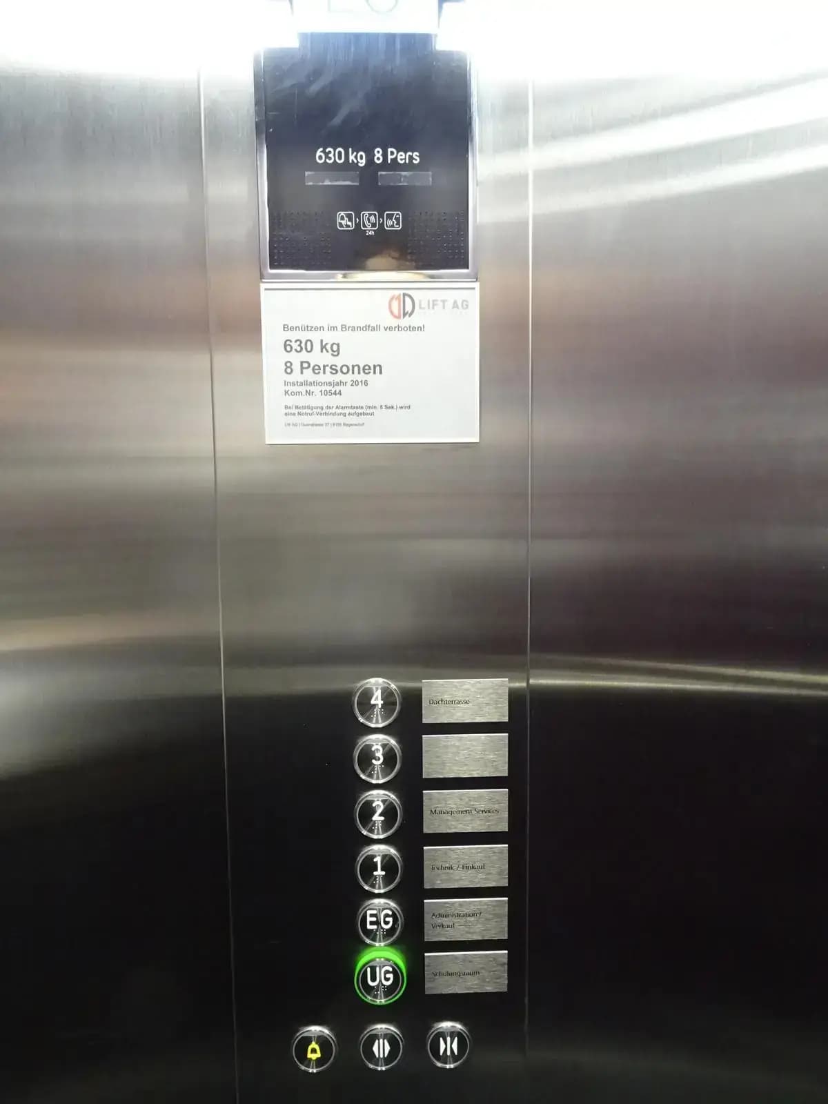 Liftkabine mit Schildern neben den Stockwerktasten